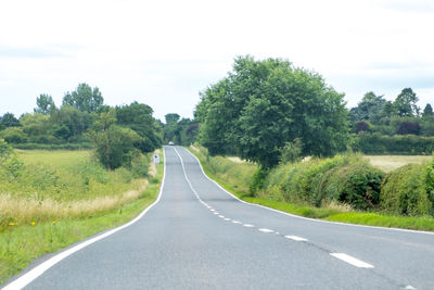 Road amidst trees against sky