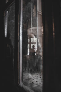 Man looking through window in building