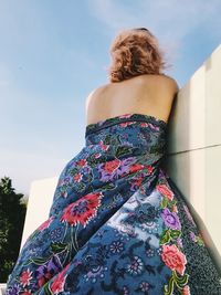 Rear view of woman standing against wall