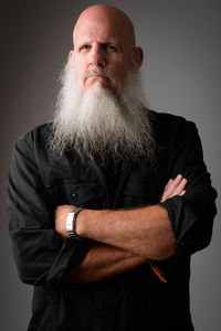 Portrait of man standing against gray background