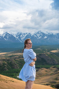 Full length of woman standing on mountain against sky