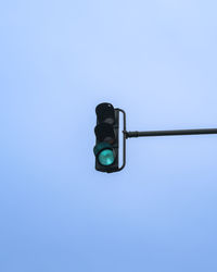 Low angle view of road sign against clear blue sky