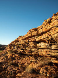 Low angle view of rock formations against clear blue sky