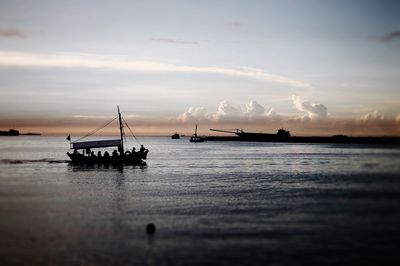 Boats in sea at sunset