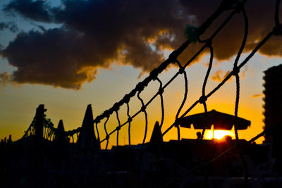 Silhouette plants against dramatic sky during sunset