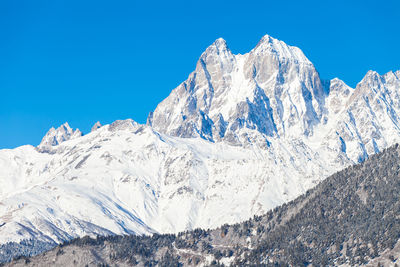 Scenic view of snowcapped mountains against clear blue sky
