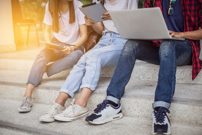 Low section of people sitting on laptop