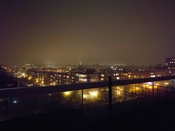 Illuminated cityscape against sky at night