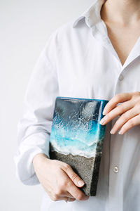 Midsection of woman holding glass