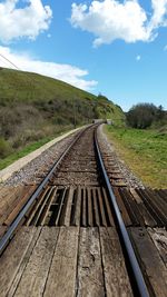 Railroad track against cloudy sky