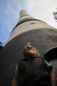 Low angle view of man standing on mountain against sky