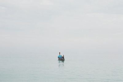 Man on boat sailing in sea against sky