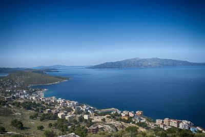 High angle view of town by sea against sky