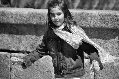 Portrait of girl standing against wall