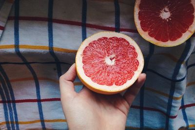 Cropped hand holding grapefruits