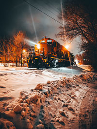 View of illuminated street against sky during winter at night