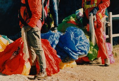 Low section of men with parachutes on field