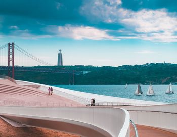 People on boat in sea against cloudy sky