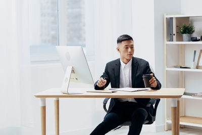 Businesswoman using laptop while sitting on table