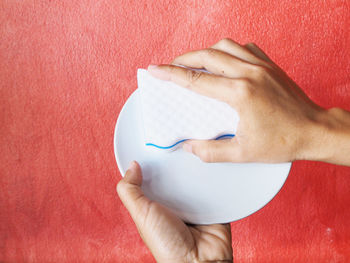 Midsection of man holding red over white background