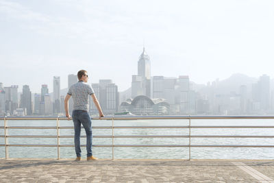 Full length of man standing by buildings against sky
