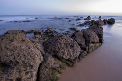 Rocks on beach against sky