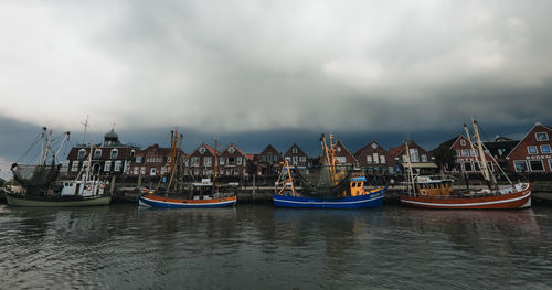 Sailboats moored in sea against sky