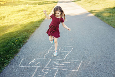 Full length of girl playing on road