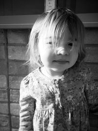 Close-up of cute girl standing by wall