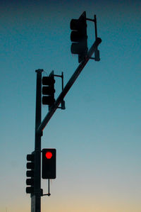 Low angle view of road signal against clear blue sky