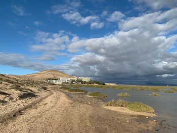 Scenic view of beach against cloudy sky