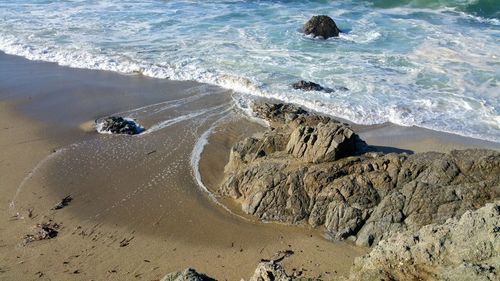 High angle view of beach and waves from cliff