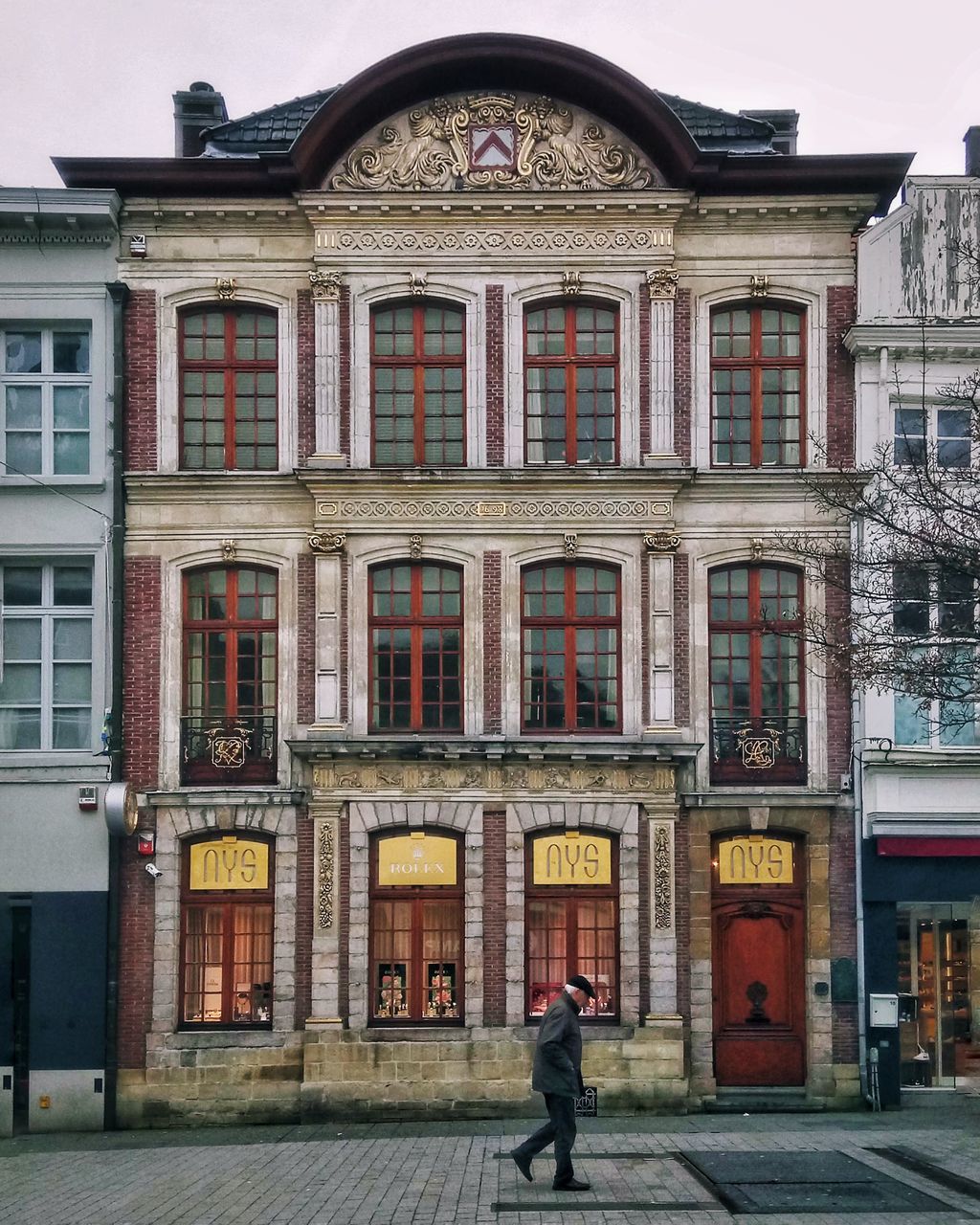 FULL LENGTH OF MAN WALKING ON STREET BY BUILDING