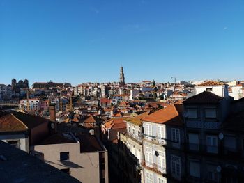 Houses in town against clear blue sky