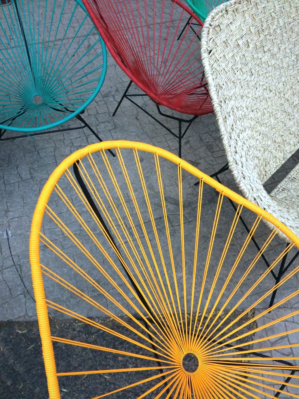 no people, day, high angle view, pattern, protection, multi colored, security, outdoors, still life, close-up, art and craft, parasol, design, yellow, absence, chair, wheel, spoke, choice, foldable