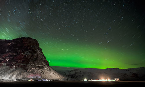 Scenic view of mountains against aurora borealis at night