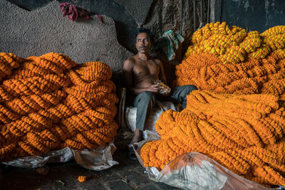 Full length portrait of a man sitting on autumn leaves