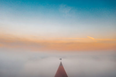 Airplane flying against sky during sunset