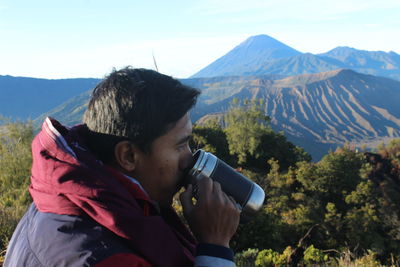 Man photographing against mountains