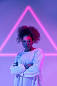 Portrait of man standing against pink background