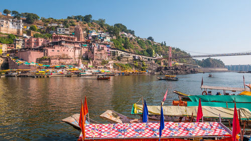 Boats moored in sea against buildings in city