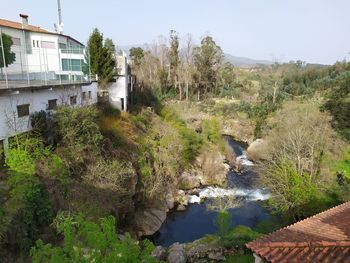 River amidst trees and buildings against sky