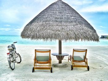 Chairs on beach against sky