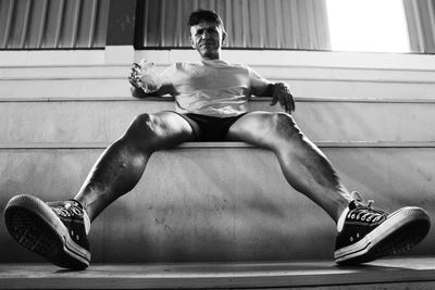 Low angle portrait of mature man sitting on steps