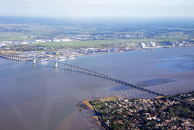 High angle view of cityscape by sea against sky