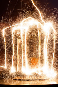 Close-up of illuminated firework display against sky at night