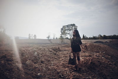 Full length of woman standing on land against sky