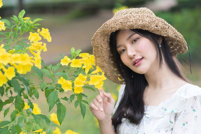 Portrait of beautiful young woman with yellow flowers