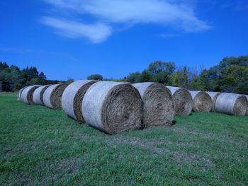 Hay bales on field against sky