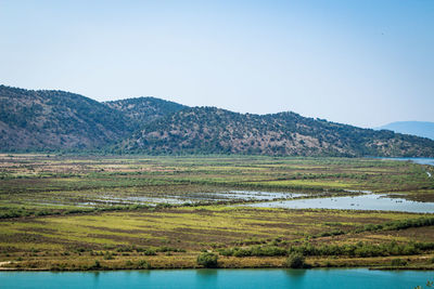 Scenic view of lake and mountains against clear sky